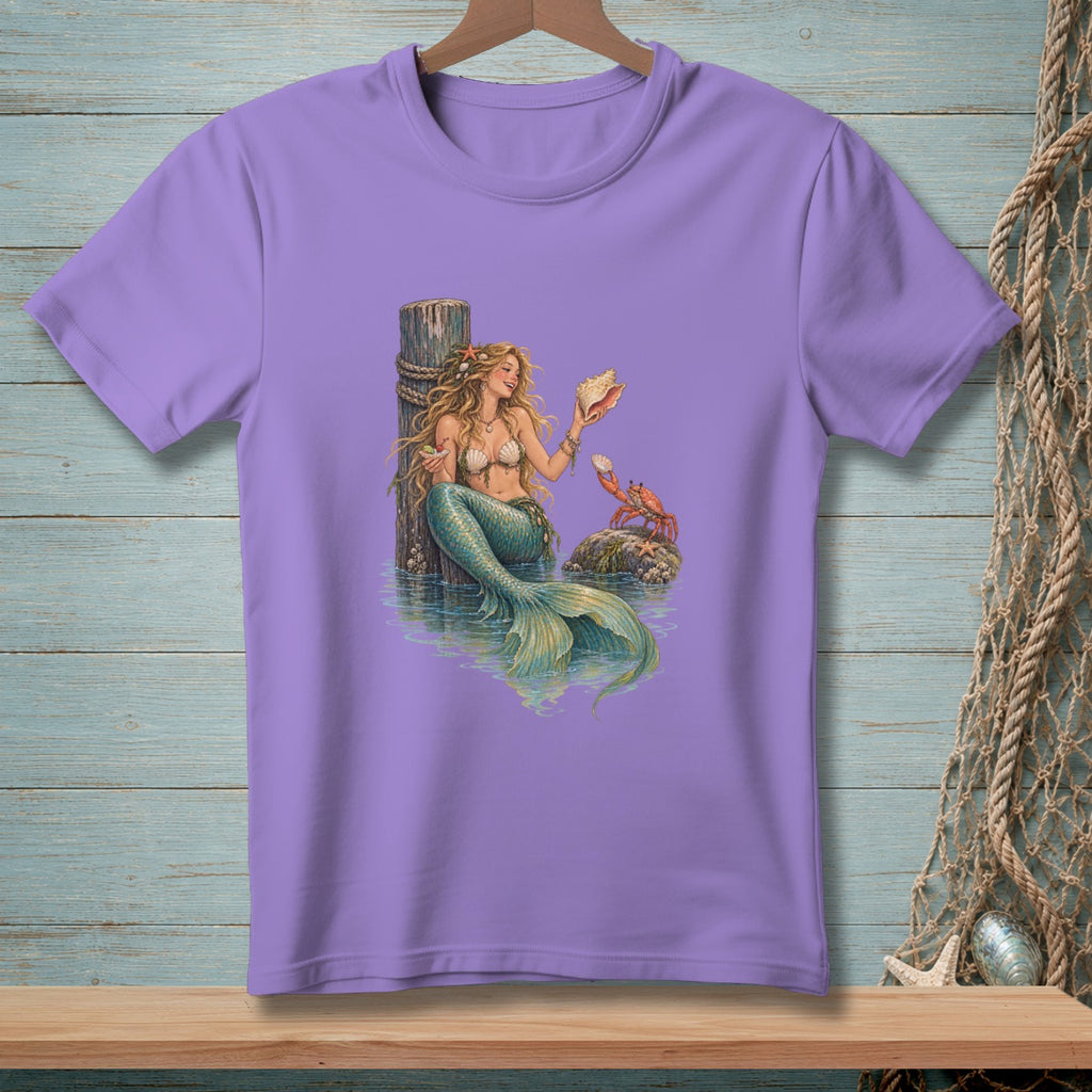 Purple t-shirt with a mermaid holding a shell next to a crab on a rock.