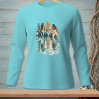 Three mermaids sit on a dock, reflecting in the water.