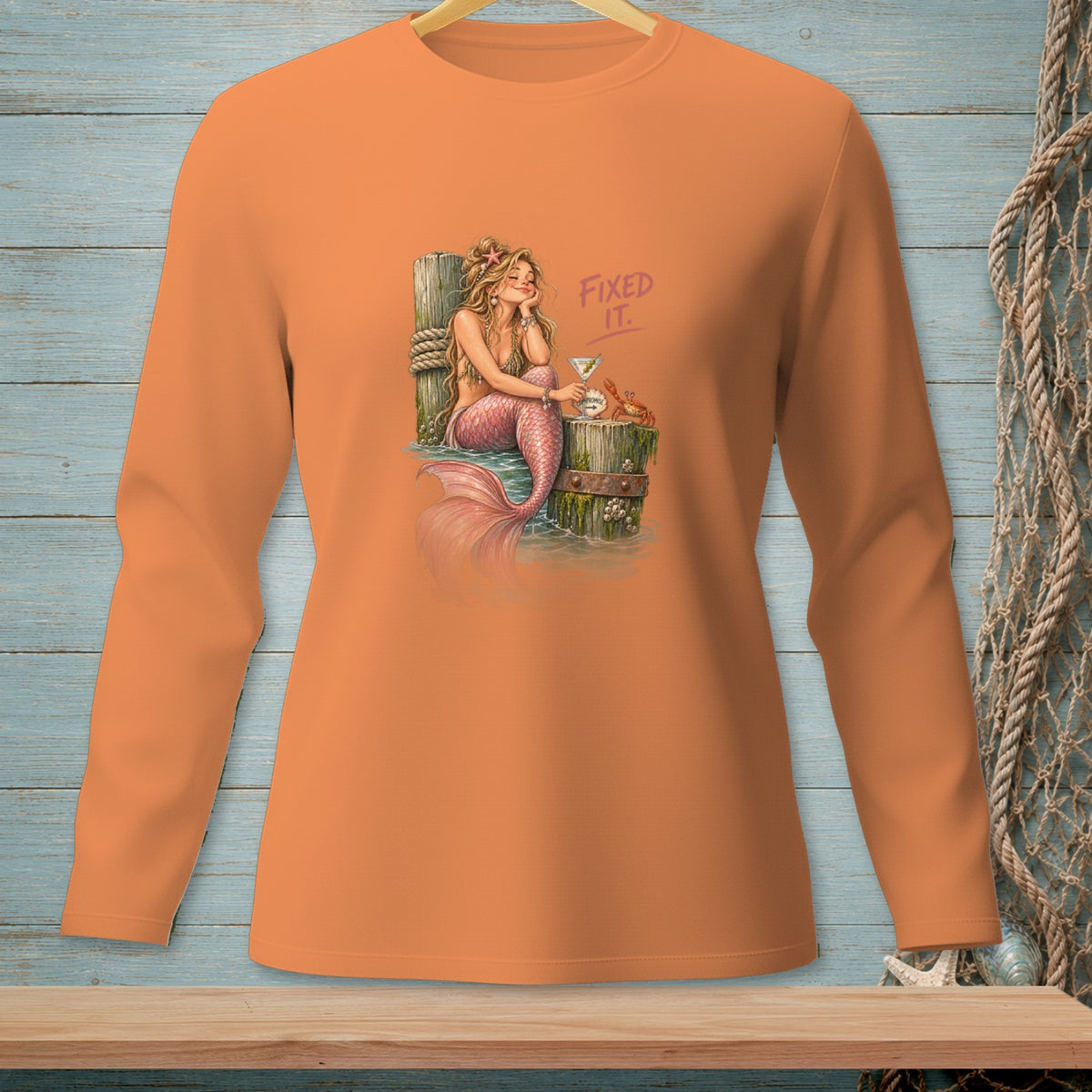 Orange long-sleeved shirt with a mermaid and crab graphic that says "Fixed It."