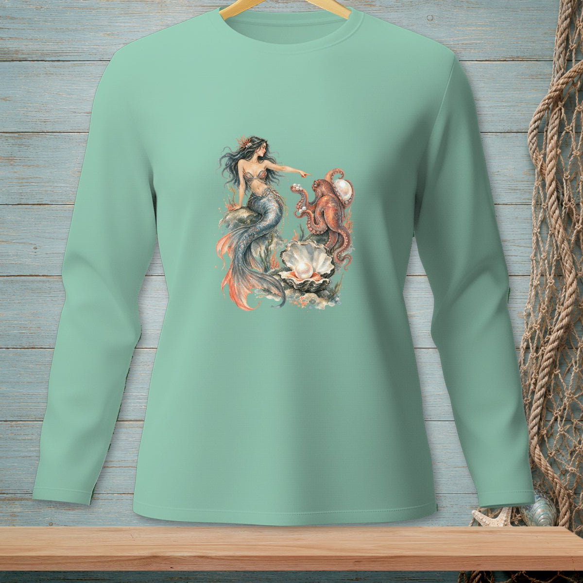 Mint green long-sleeve shirt with mermaid and octopus graphic on a pearl.