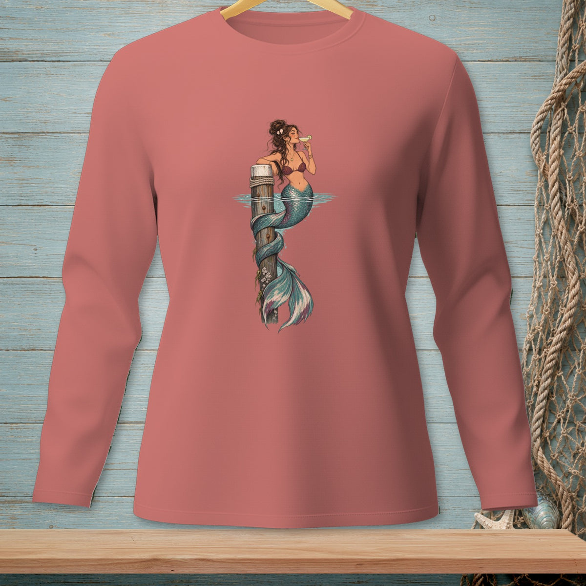 Mermaid with drink on pier, print on pink long-sleeved shirt.