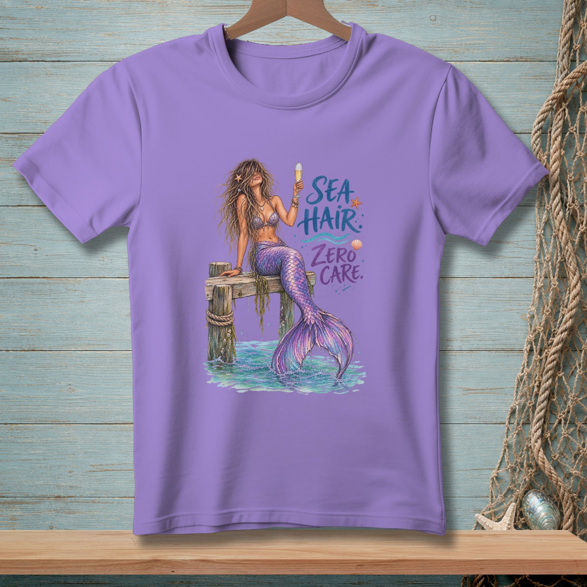 Purple t-shirt with a mermaid design and text "Sea Hair Zero Care".
