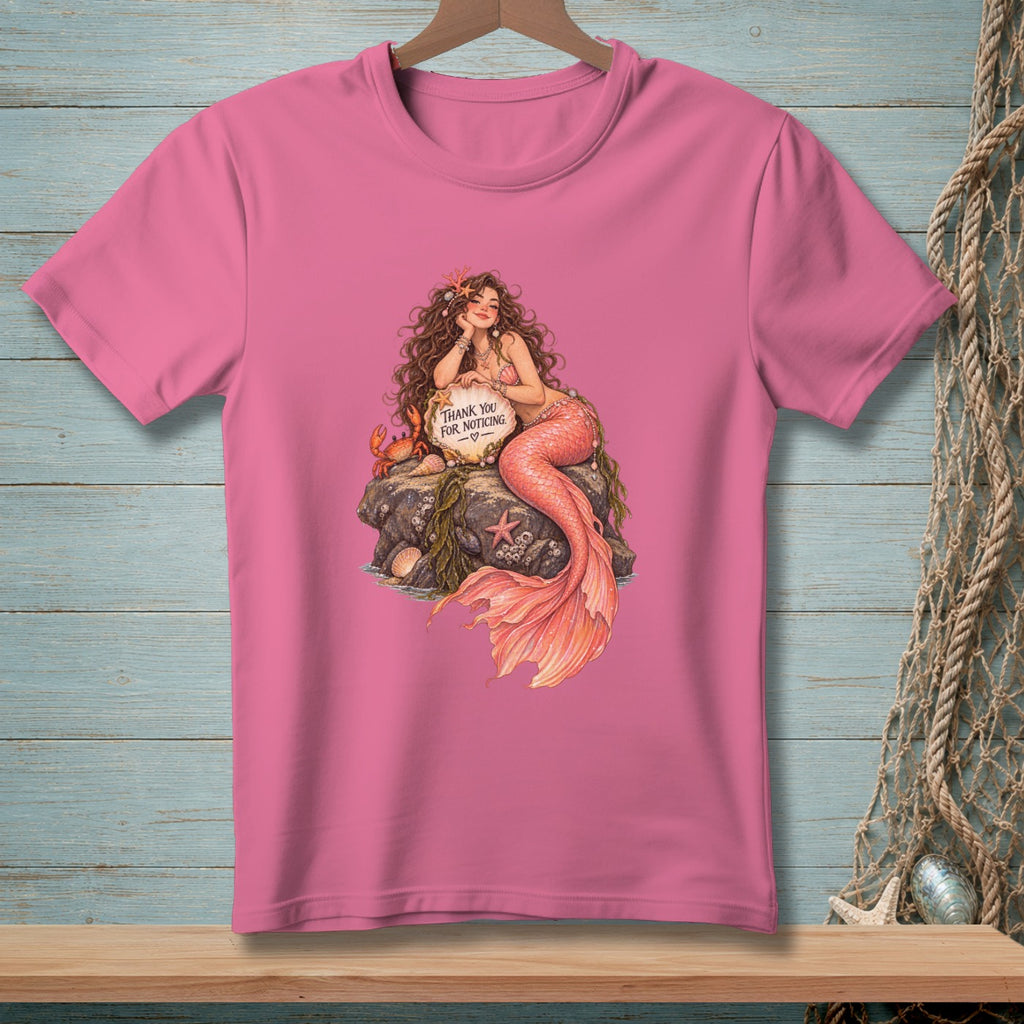 Pink t-shirt with a mermaid sitting on a rock holding a "Thank You For Noticing" sign.