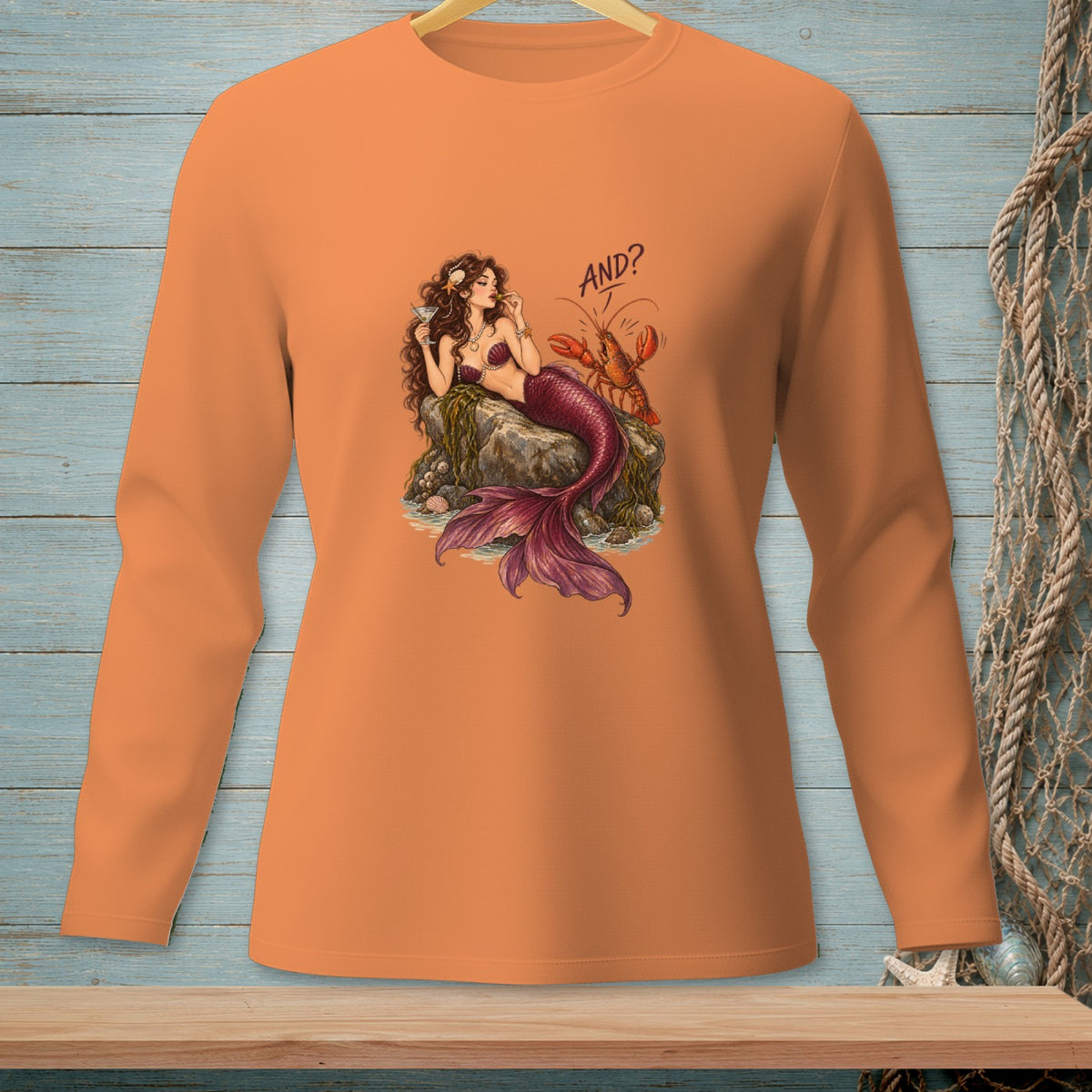 Orange long-sleeve shirt with mermaid and lobster graphic that says "AND?".
