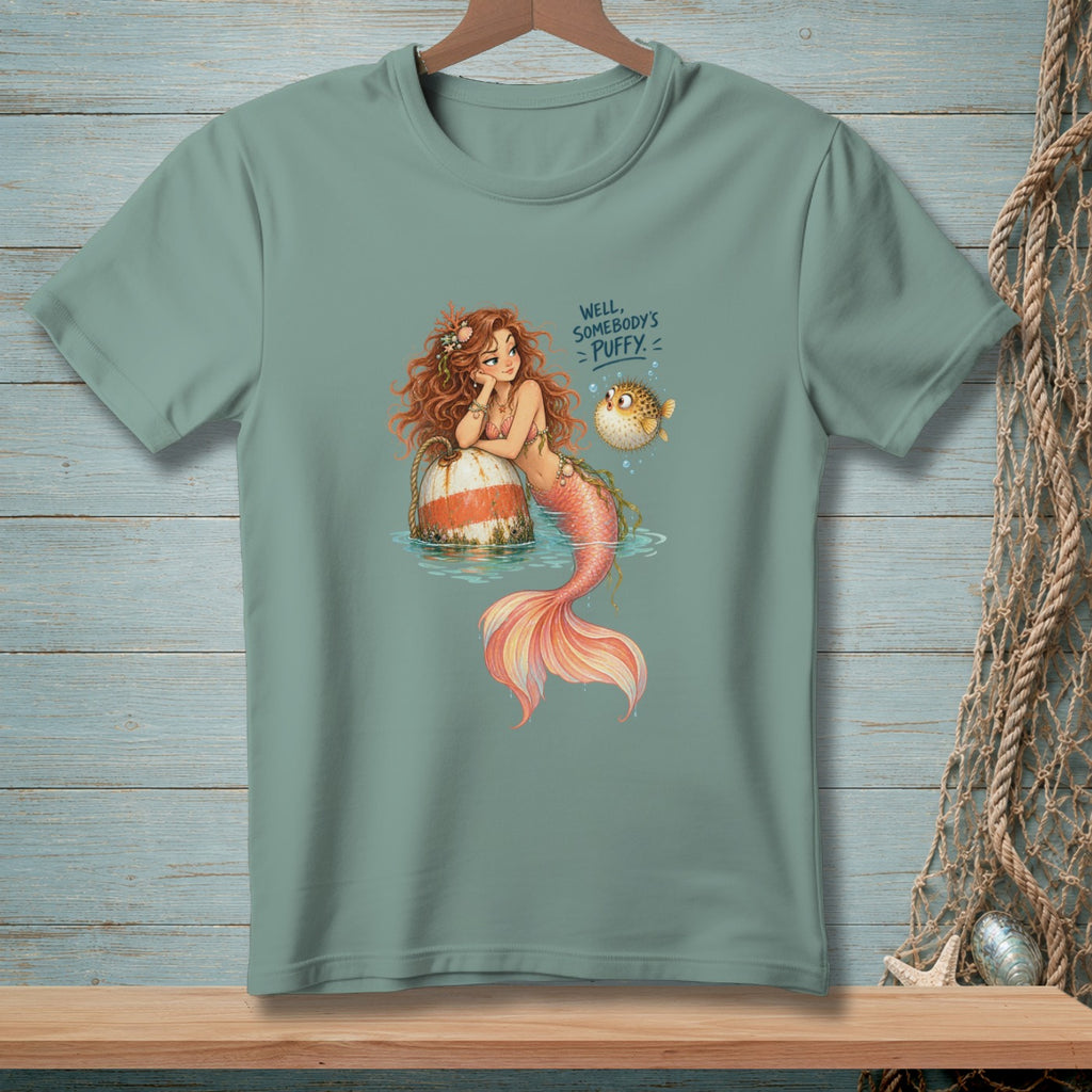 Mermaid rests on buoy with pufferfish and text "Well, somebody's puffy."