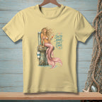 Pale yellow t-shirt with a mermaid illustration and the text "Salty Hair, Don't Care."