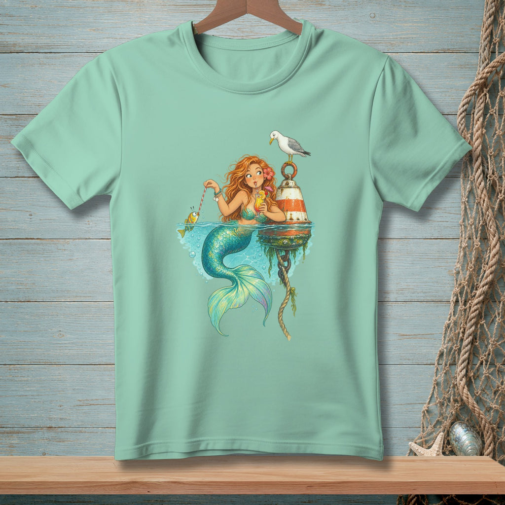 Mint green t-shirt with a mermaid fishing for a fish while holding a drink.