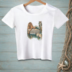 White t-shirt with a graphic of a mermaid on a dock, reading "Whatever Floats Your Boat."
