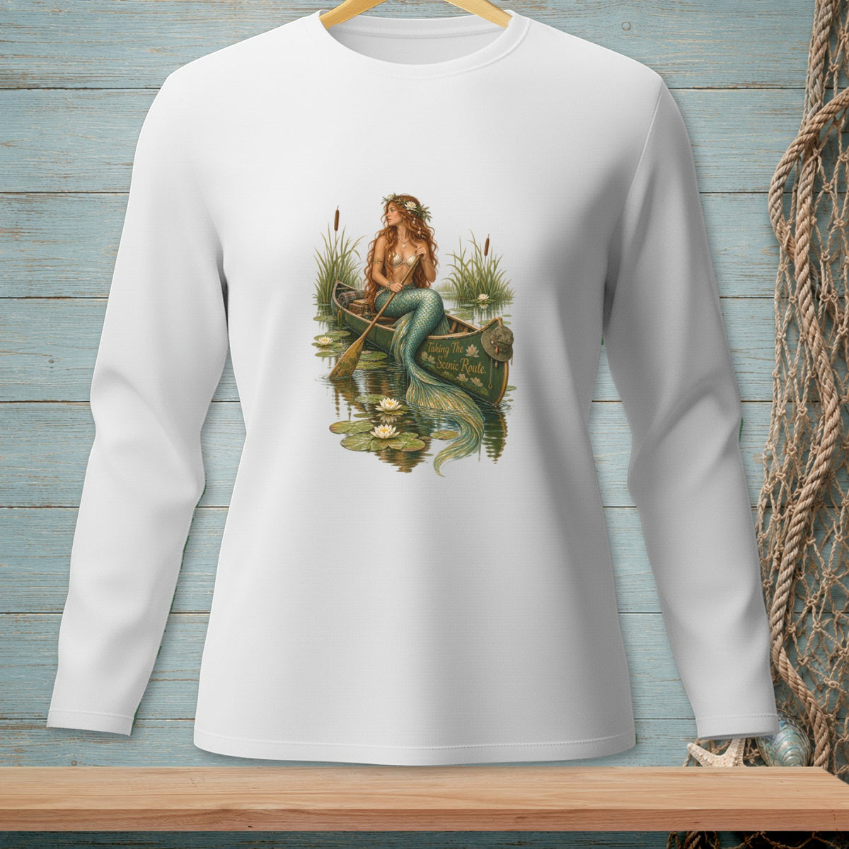 Mermaid in canoe with paddle, lily pads, and text "Taking The Scenic Route".