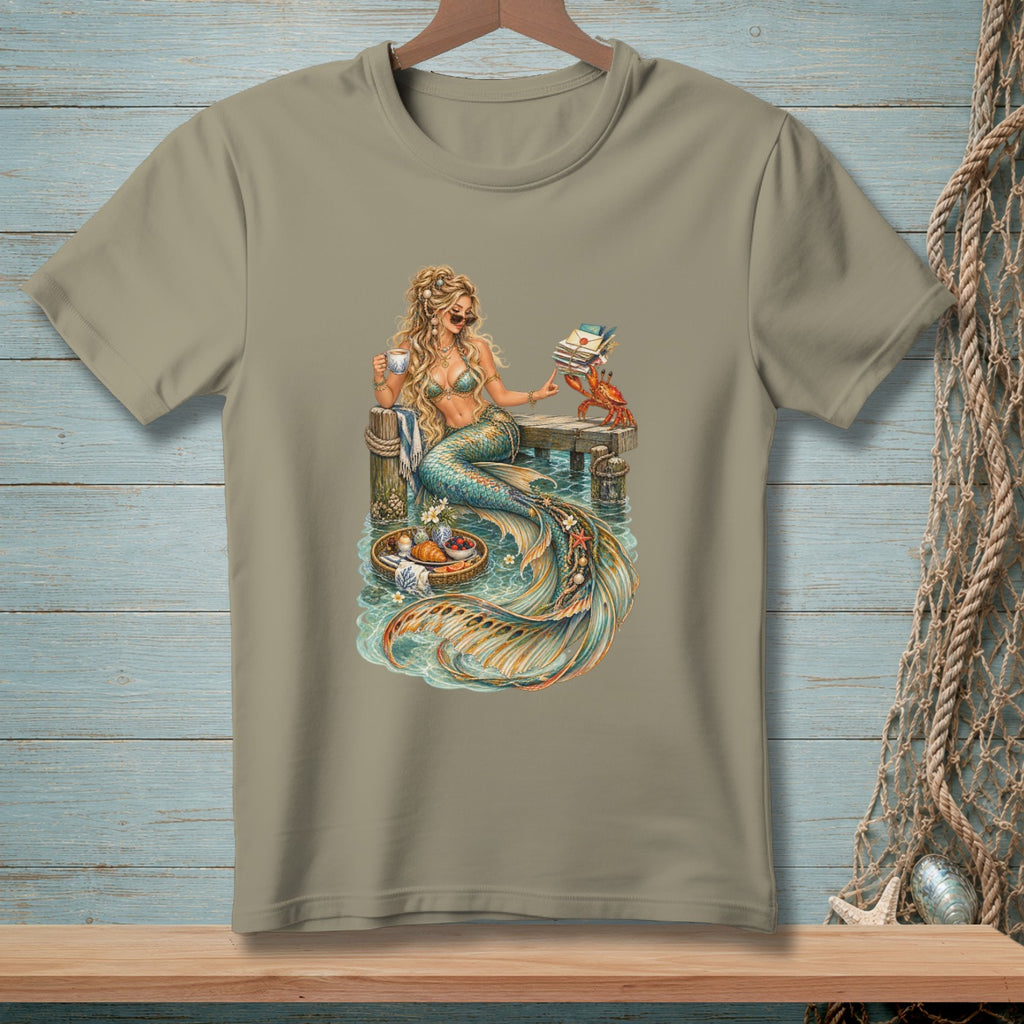 T-shirt graphic of a mermaid with coffee, books, and a crab on a pier.