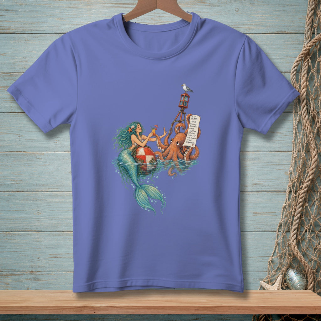 A periwinkle t-shirt featuring an illustration of a mermaid, an octopus holding a to-do list, and a lighthouse.