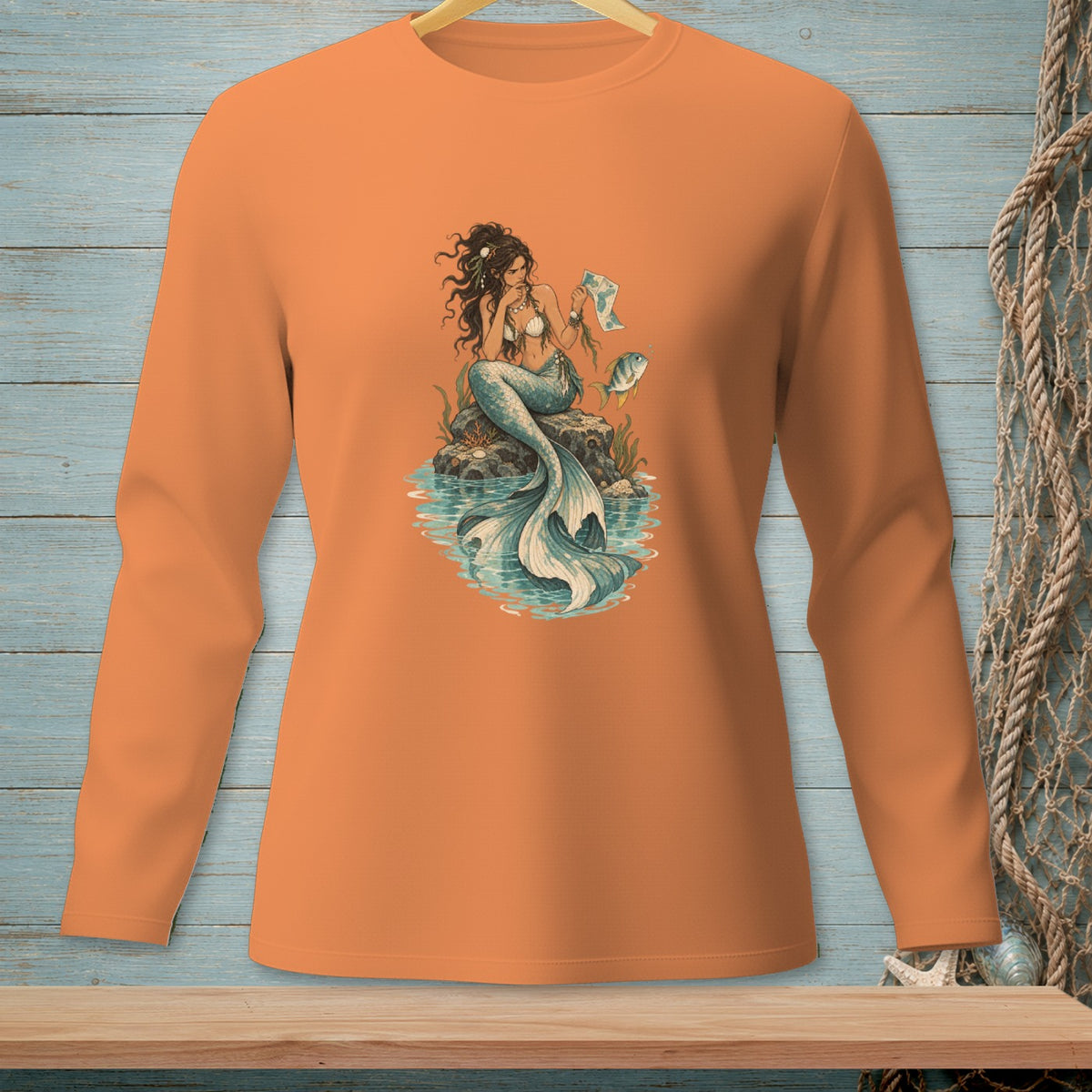 Long-sleeve orange shirt with a detailed illustration of a mermaid on a rock.