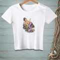 A white t-shirt on a wooden background features a graphic of a mermaid with a face mask relaxing on a rock.