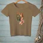 Mermaid holding a mirror with an octopus on a dock, on a brown t-shirt.
