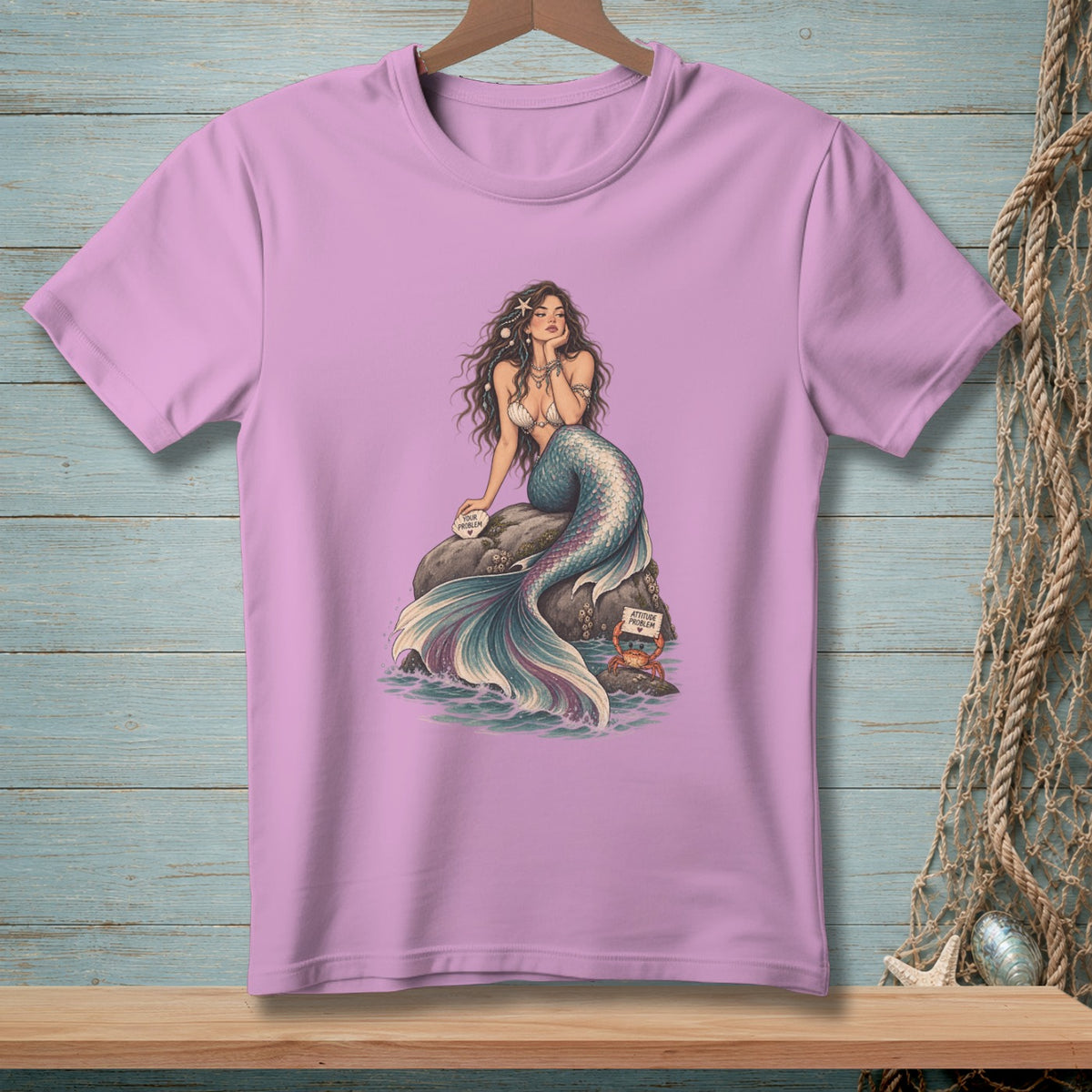 Purple t-shirt with a mermaid sitting on a rock and a crab with a sign.