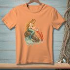 Peach t-shirt with mermaid and lobster art, featuring a mermaid sitting on a rock with a pearl.