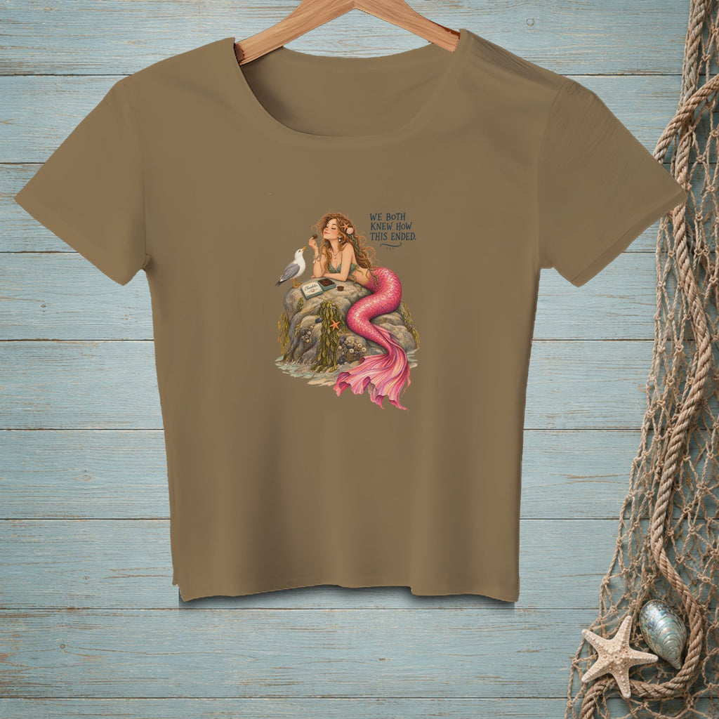 Mermaid on rocks with a seagull, eating chocolate, with text "We both knew how this ended."