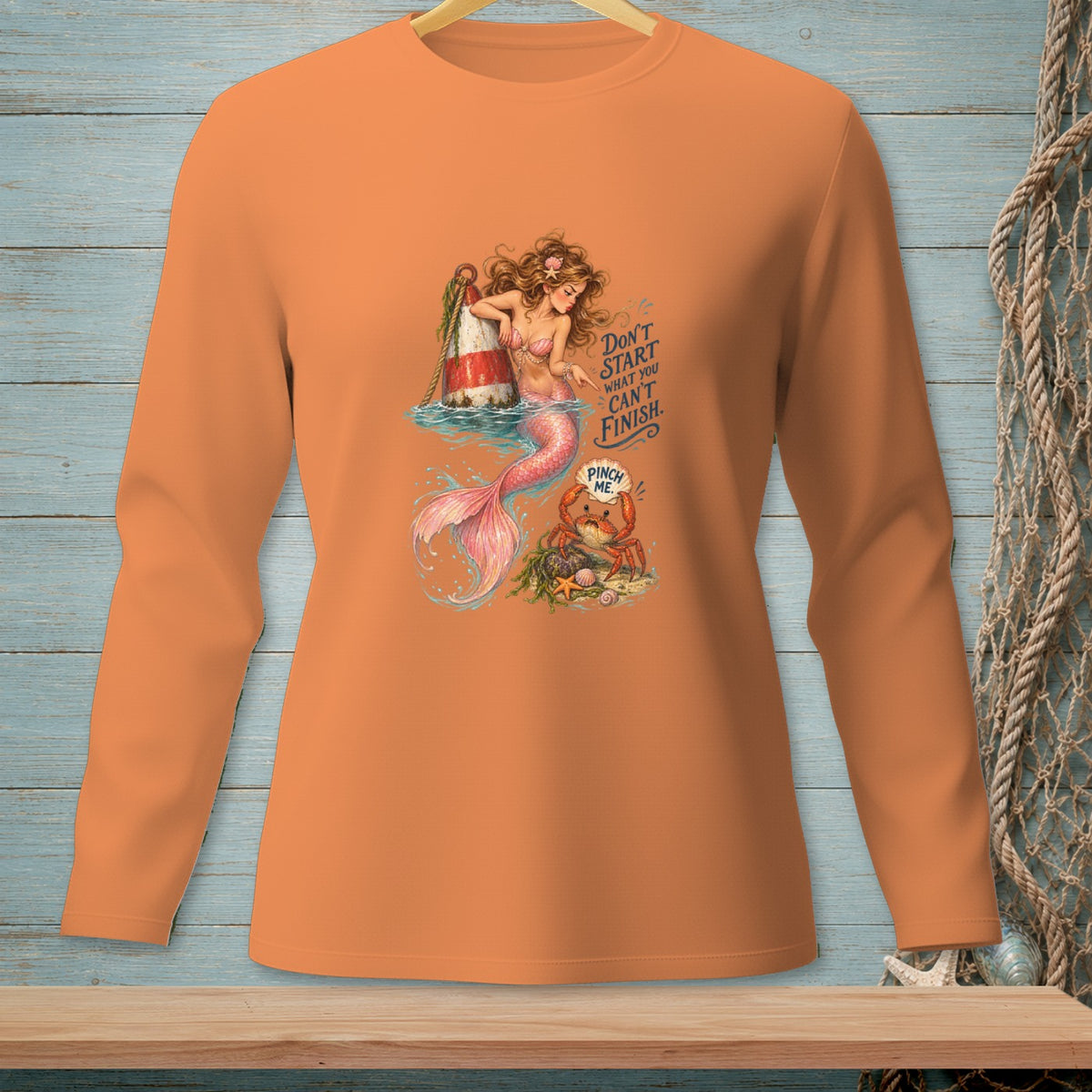 Orange long-sleeve shirt with a mermaid, crab, and text graphic.
