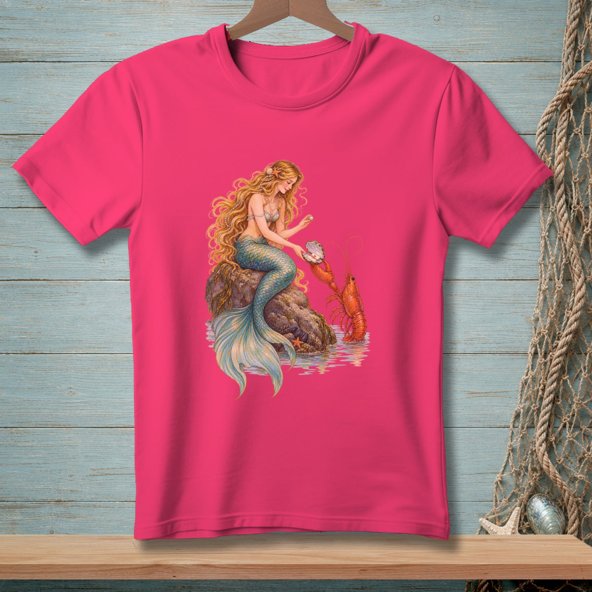 Mermaid sitting on rock with lobster and pearl in a seashell on a pink t-shirt.