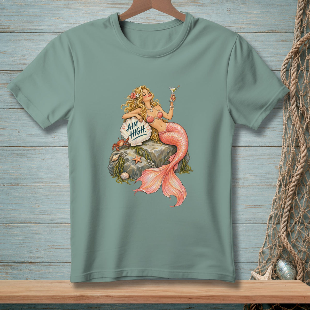 Mermaid with pink tail holding a martini glass and saying "Aim High."