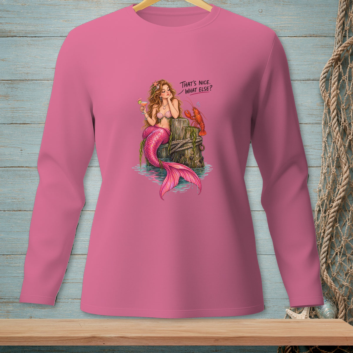 Pink long-sleeved shirt featuring a mermaid and lobster with text "That's Nice. What Else?".