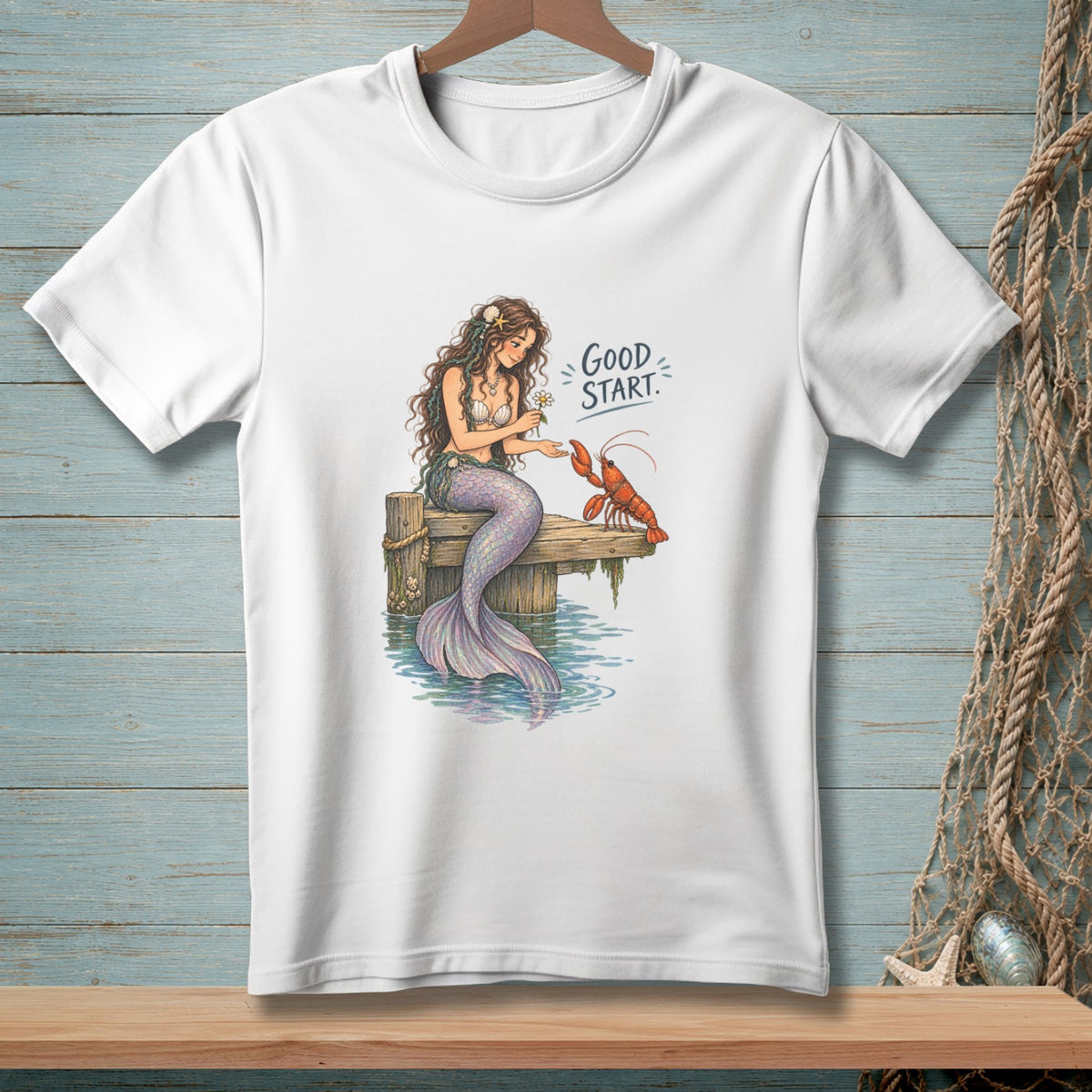 White t-shirt with illustration of mermaid and lobster, text "Good Start."