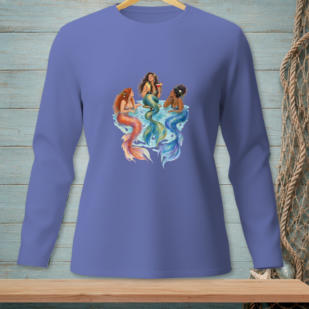 Three mermaids with colorful tails relax together in blue water.