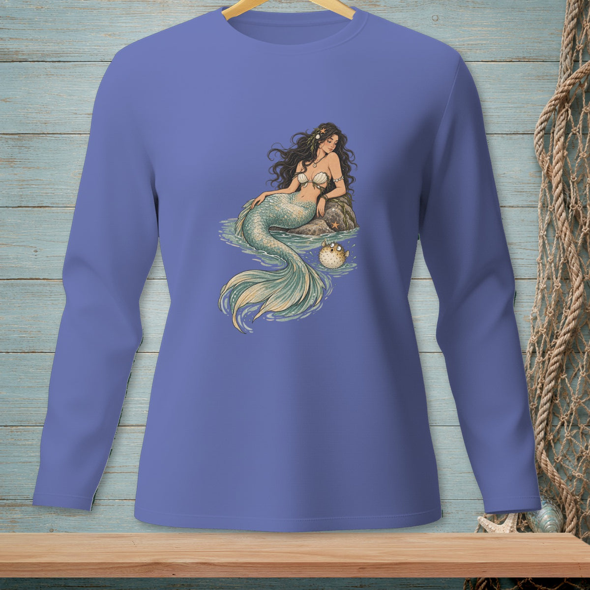 Long sleeve t-shirt with a mermaid sitting on a rock next to a pufferfish.
