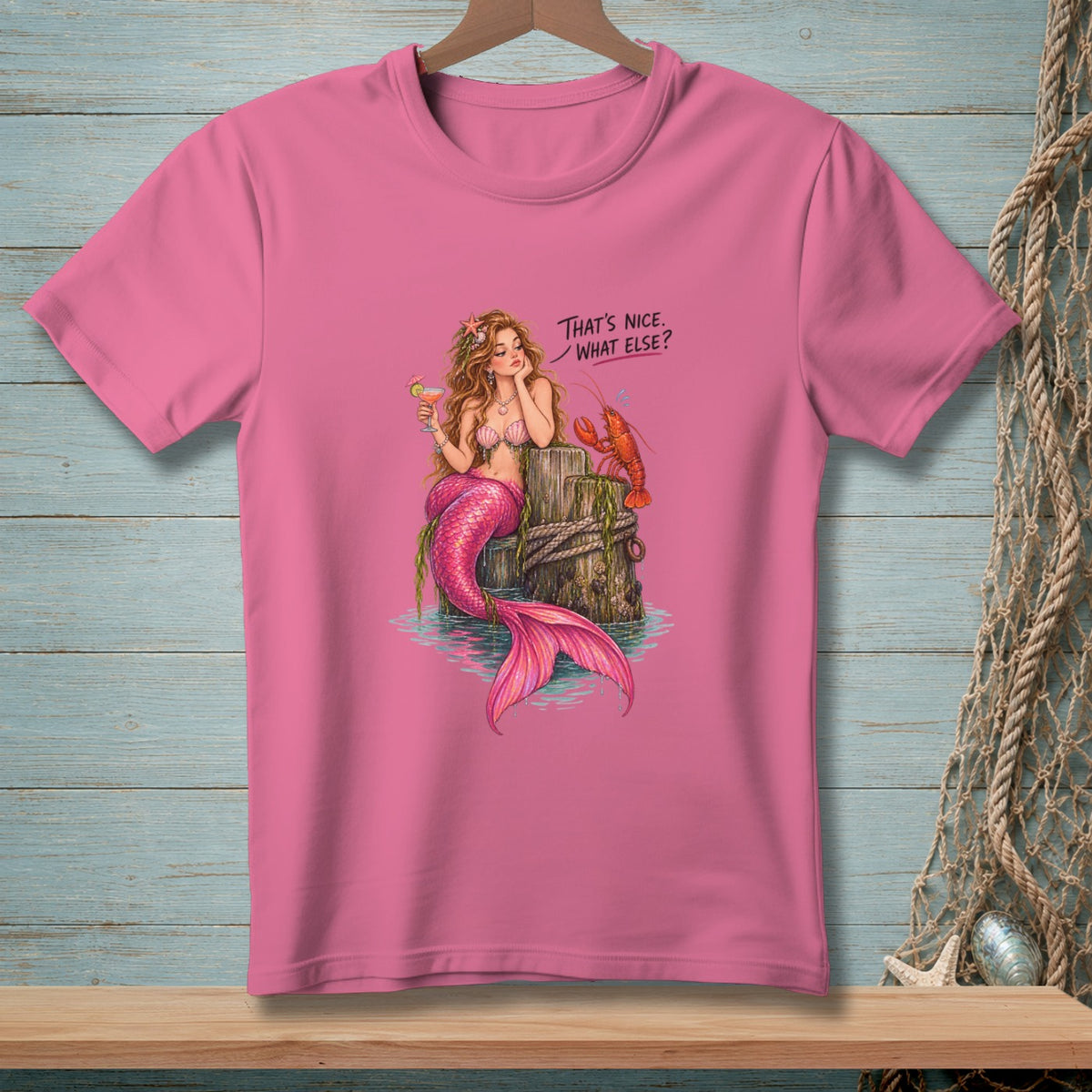 Pink t-shirt with mermaid, lobster, and text "That's Nice. What Else?".