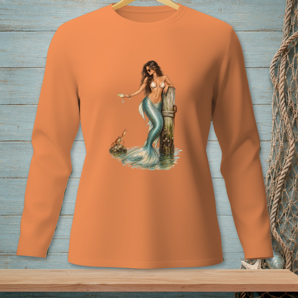 Orange long-sleeve shirt with a mermaid graphic holding a drink.