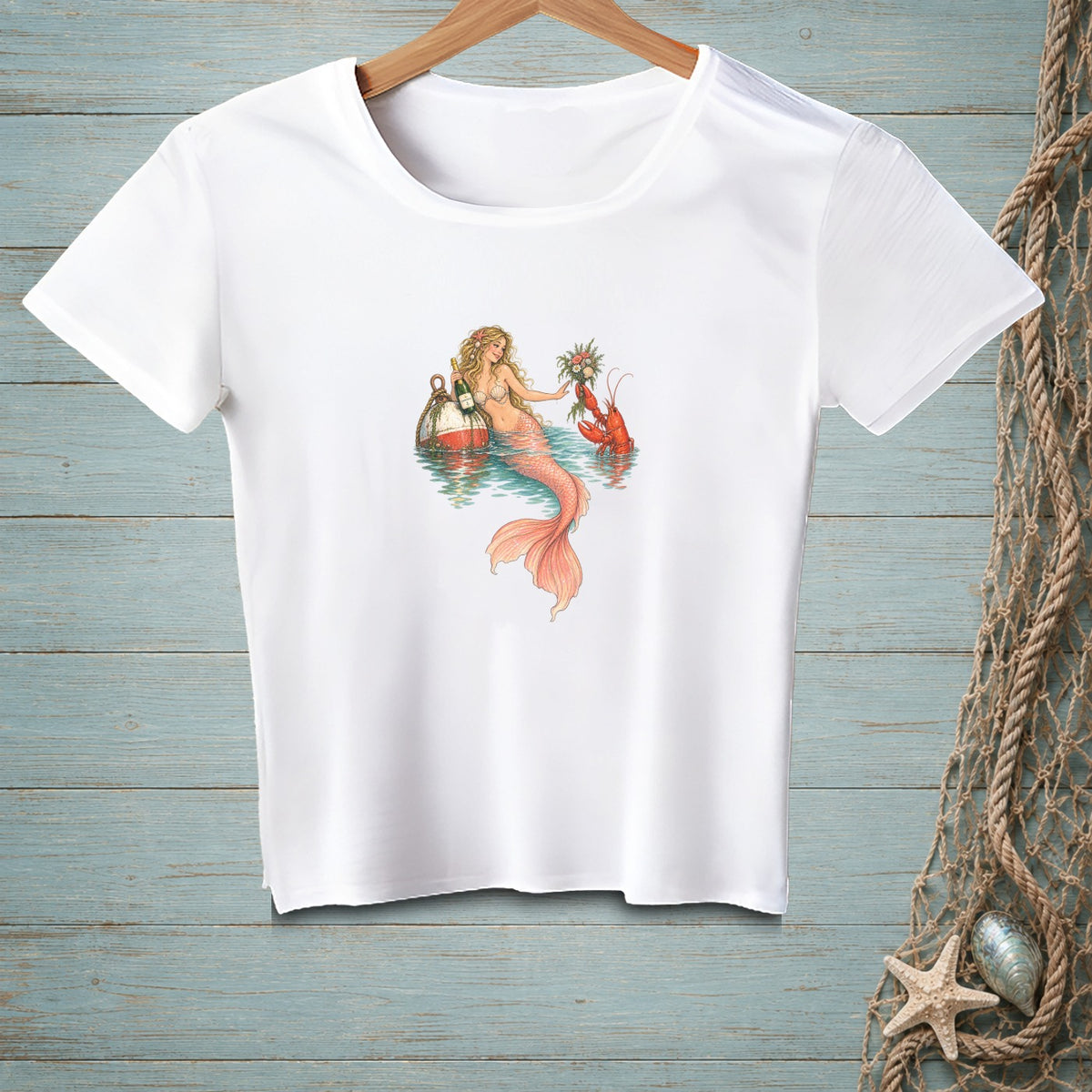 White t-shirt with a mermaid, lobster, buoys, and flowers illustration.