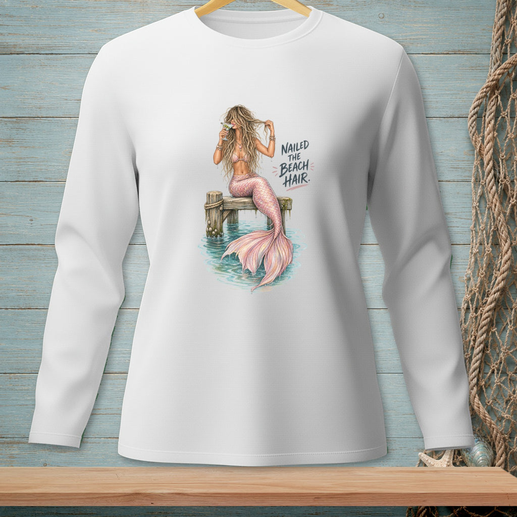 Illustration of a mermaid with pink tail on dock, holding a drink, text reads "Nailed the Beach Hair."