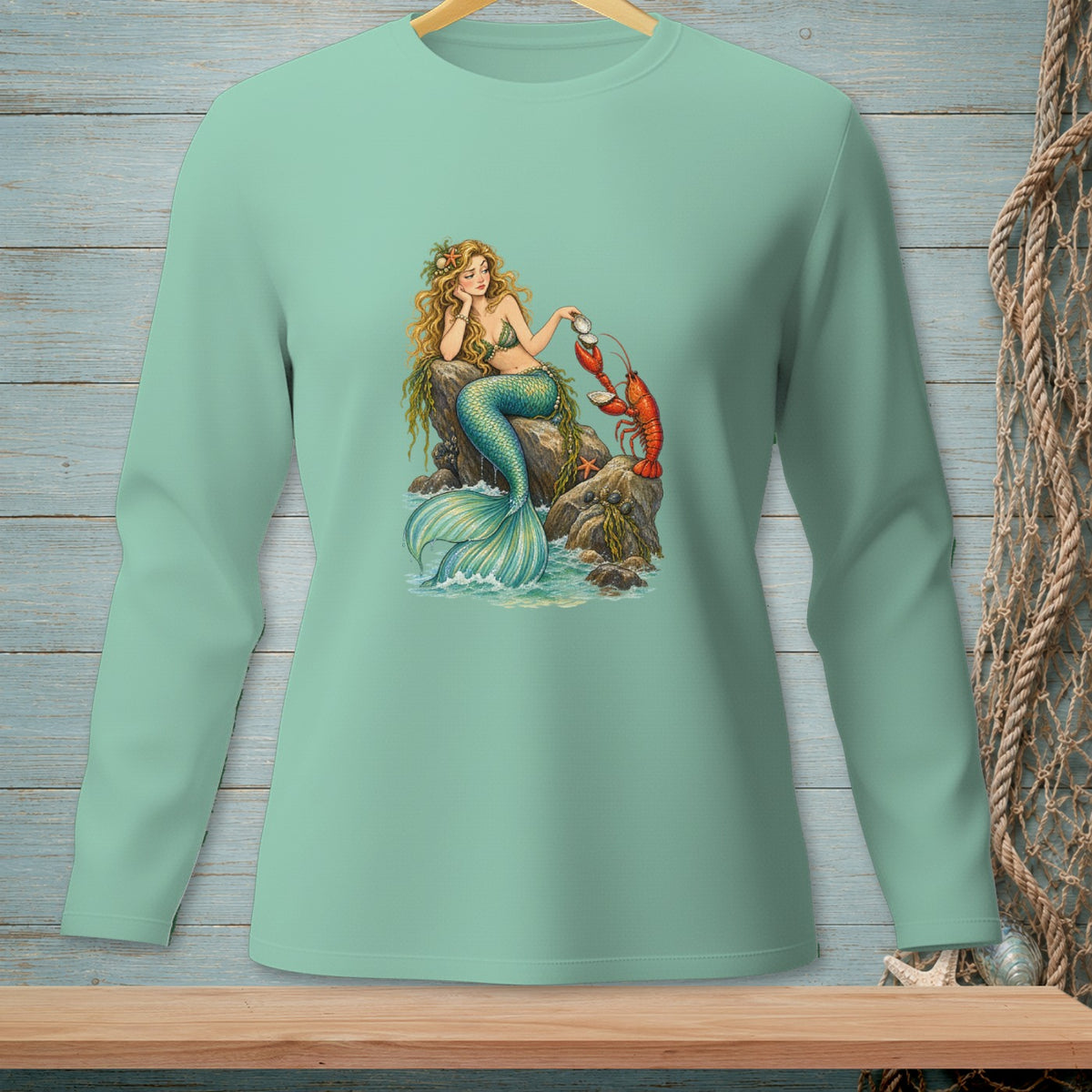 Mint green long-sleeve shirt with a mermaid and lobster illustration.