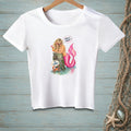 White t-shirt graphic with a mermaid, crab, and text "BE HUMBLE." and "ABOUT WHAT?".