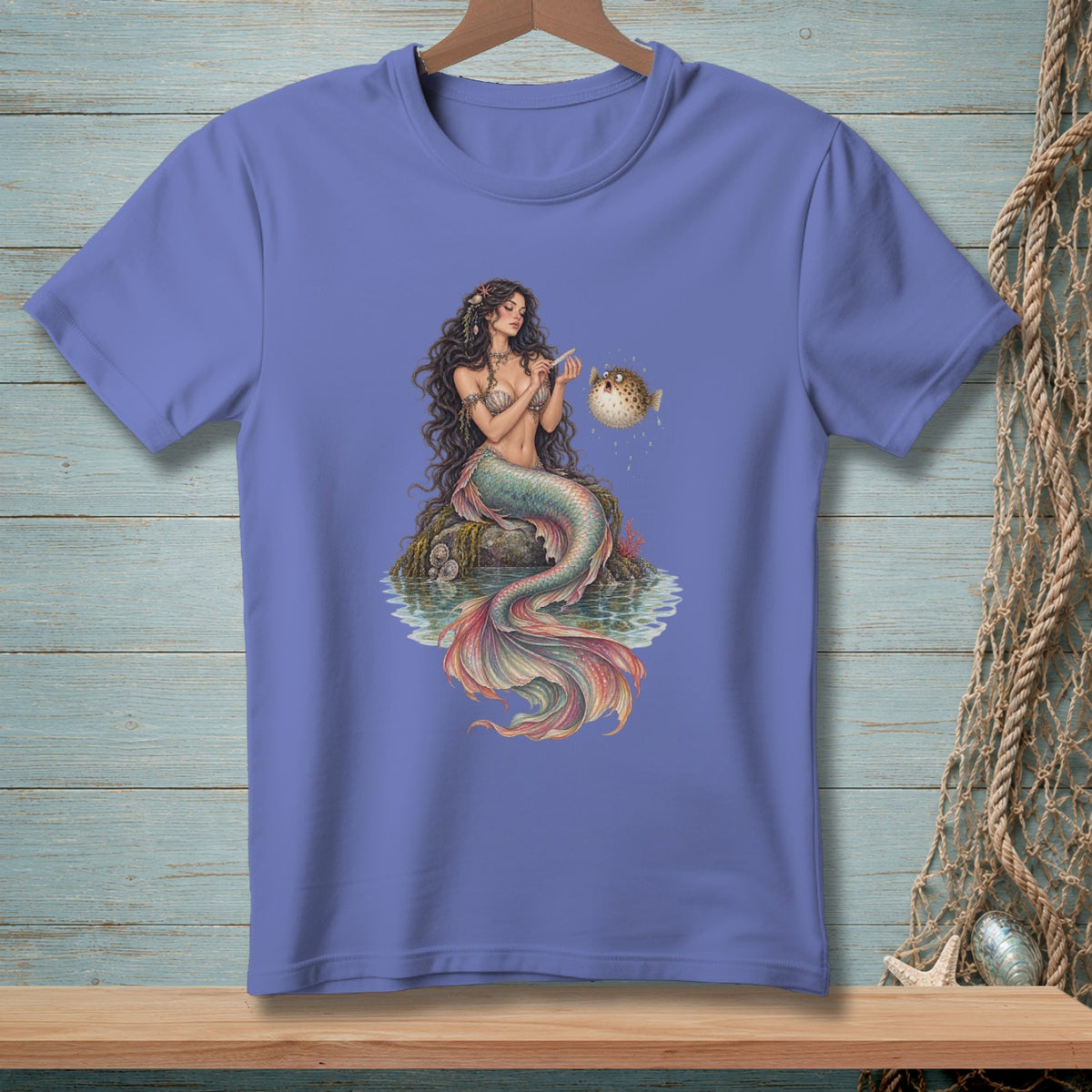 Mermaid sitting on rocks with a pufferfish, printed on a t-shirt.
