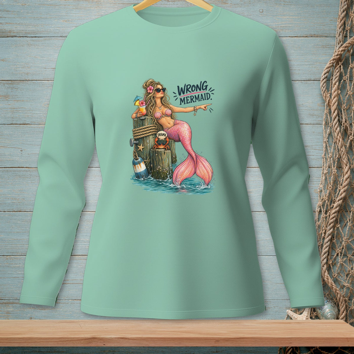 Mint green long sleeve shirt with a graphic of a mermaid on a dock, saying "WRONG MERMAID."