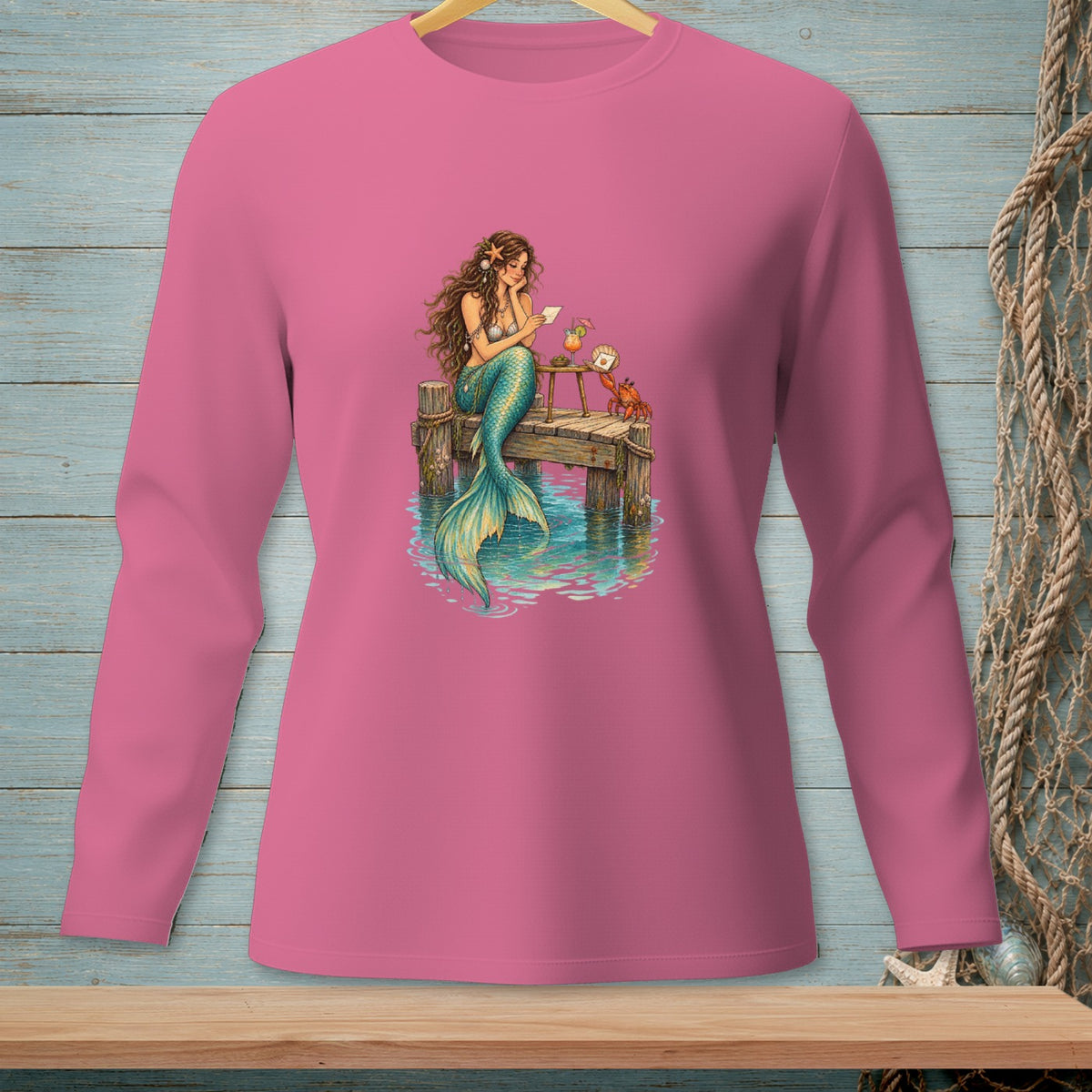 Mermaid sitting on dock reading letter with crab and drink.
