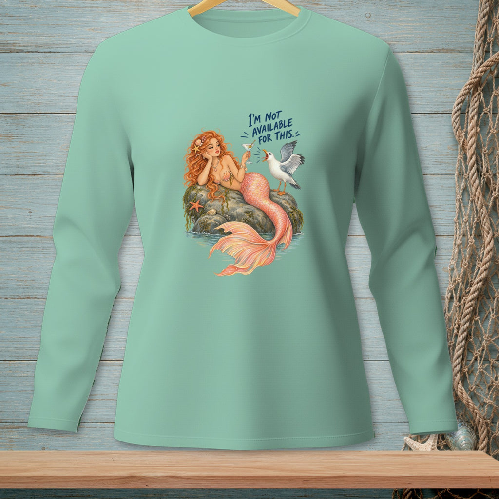 Mint green long-sleeve shirt with a mermaid and seagull graphic saying "I'm not available for this."