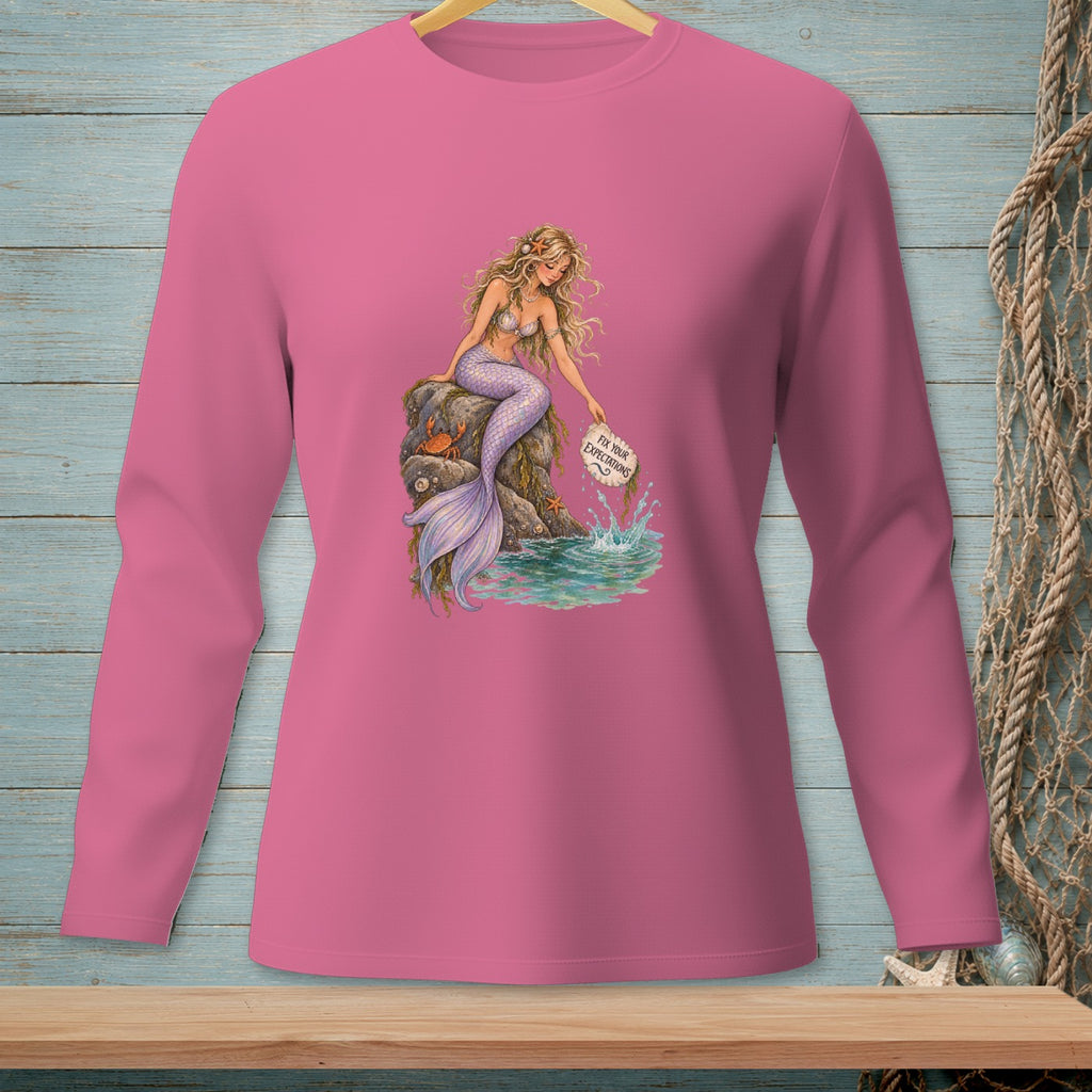 Pink long-sleeve shirt with a mermaid sitting on a rock holding a sign.