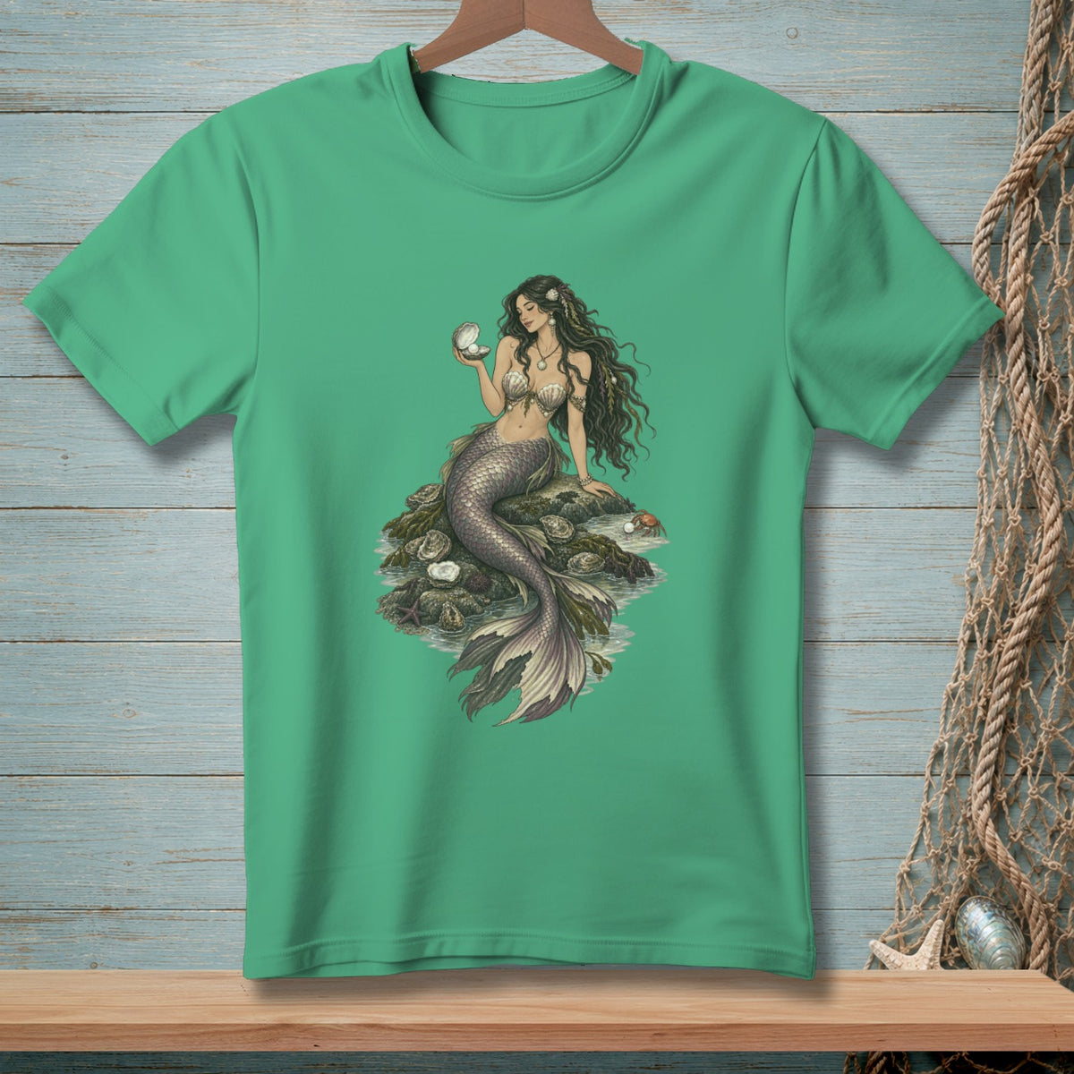 Green t-shirt with illustration of a mermaid holding a pearl.