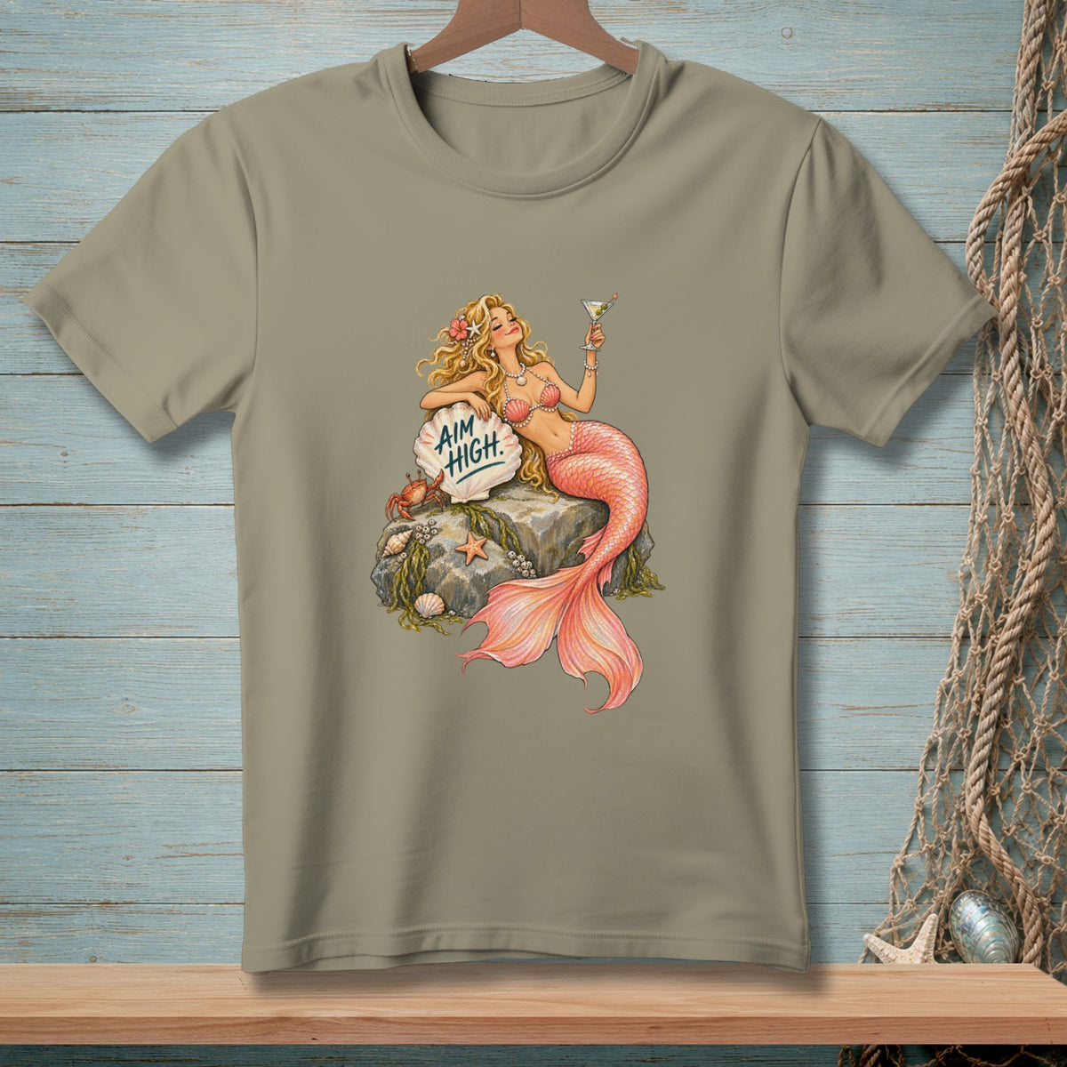 Mermaid with cocktail on rock, text "AIM HIGH.", crab, shells, starfish.