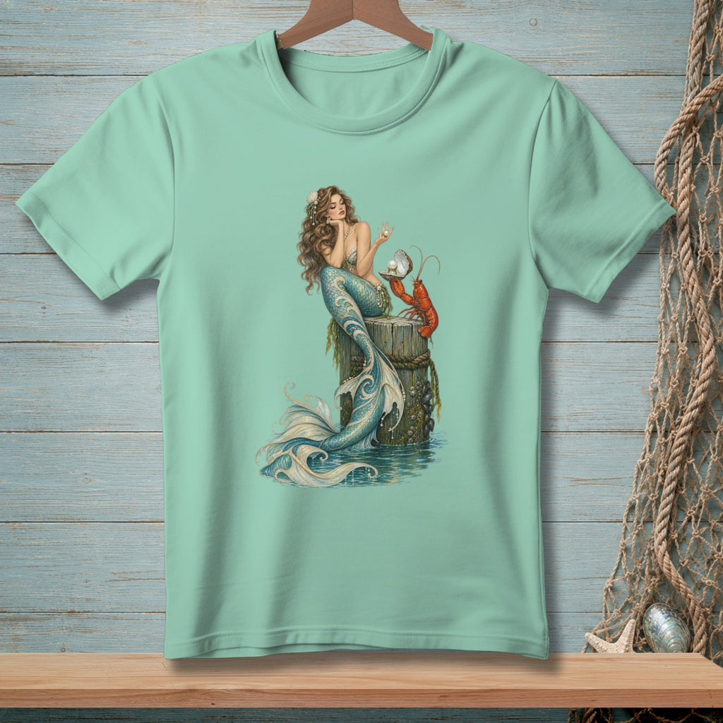Mint t-shirt with a mermaid and lobster illustration on a wooden post.