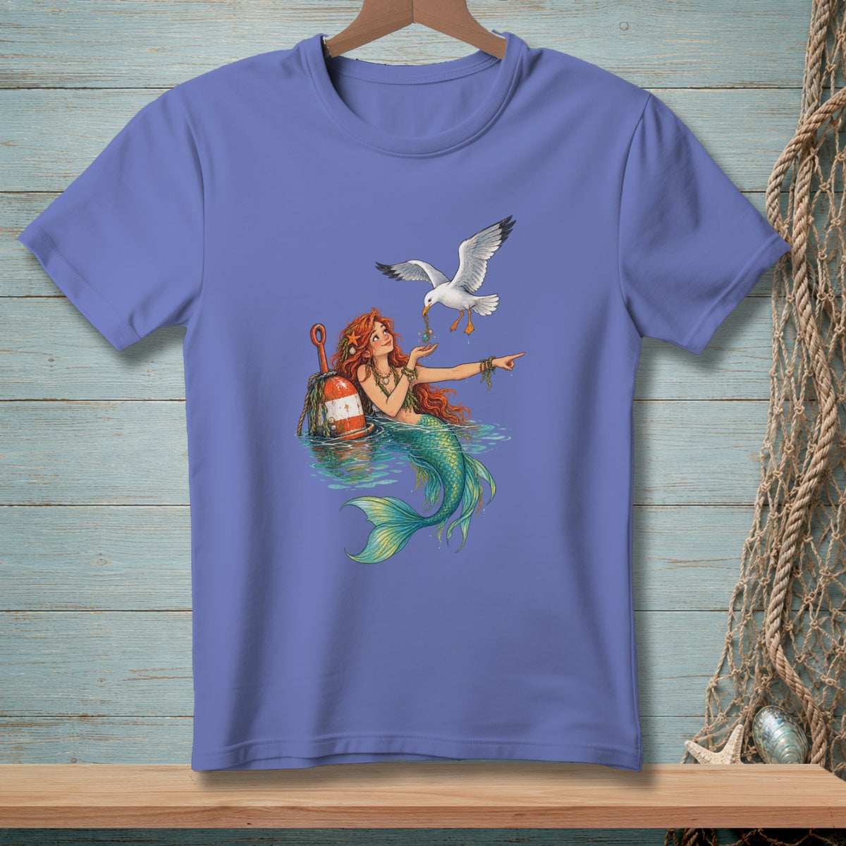Mermaid with red hair feeds a seagull pearls from a buoy in the water.