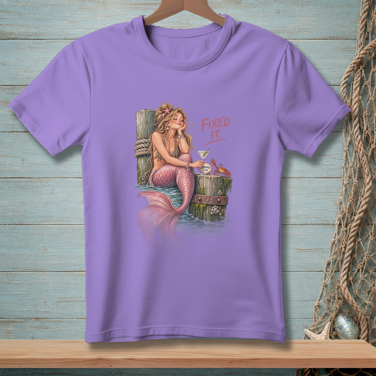 Purple t-shirt with a mermaid, martini, crab, and text "FIXED IT."