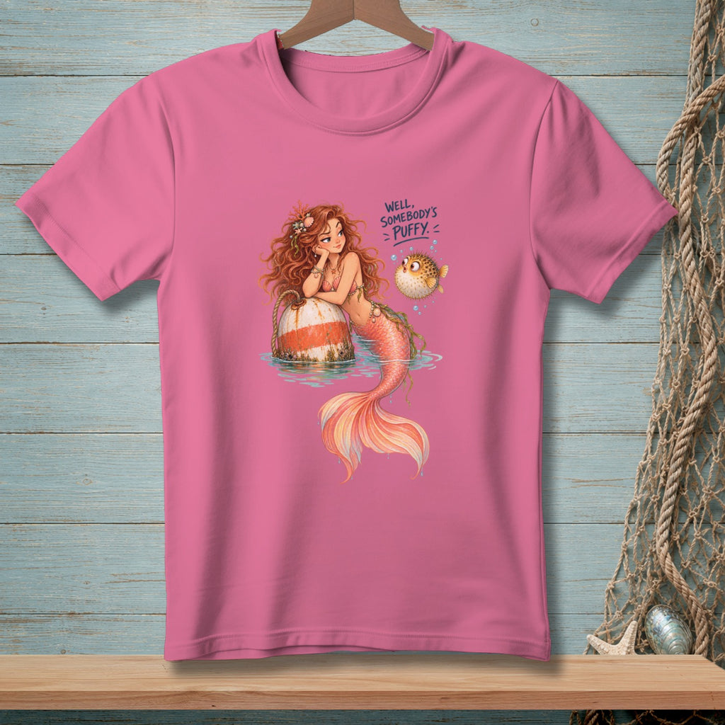 Pink t-shirt with a mermaid, pufferfish, and text that reads "Well, Somebody's Puffy."