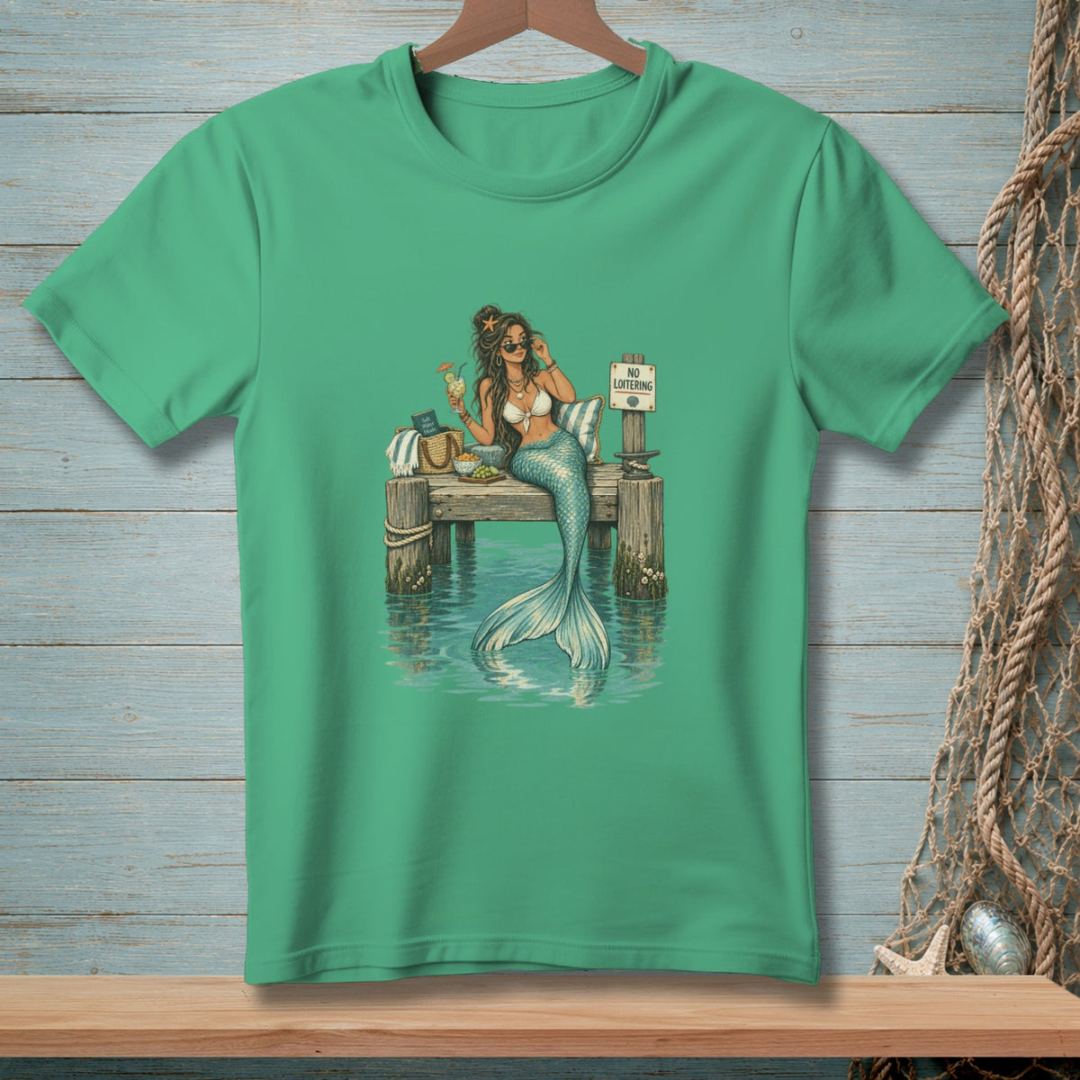 Mermaid with drink and sunglasses sits on a dock with a "No Loitering" sign.