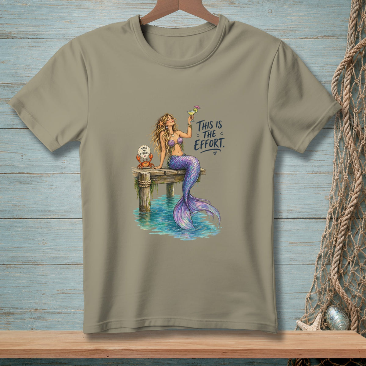 Mermaid on dock with cocktail and crab. Text: "This is the effort."