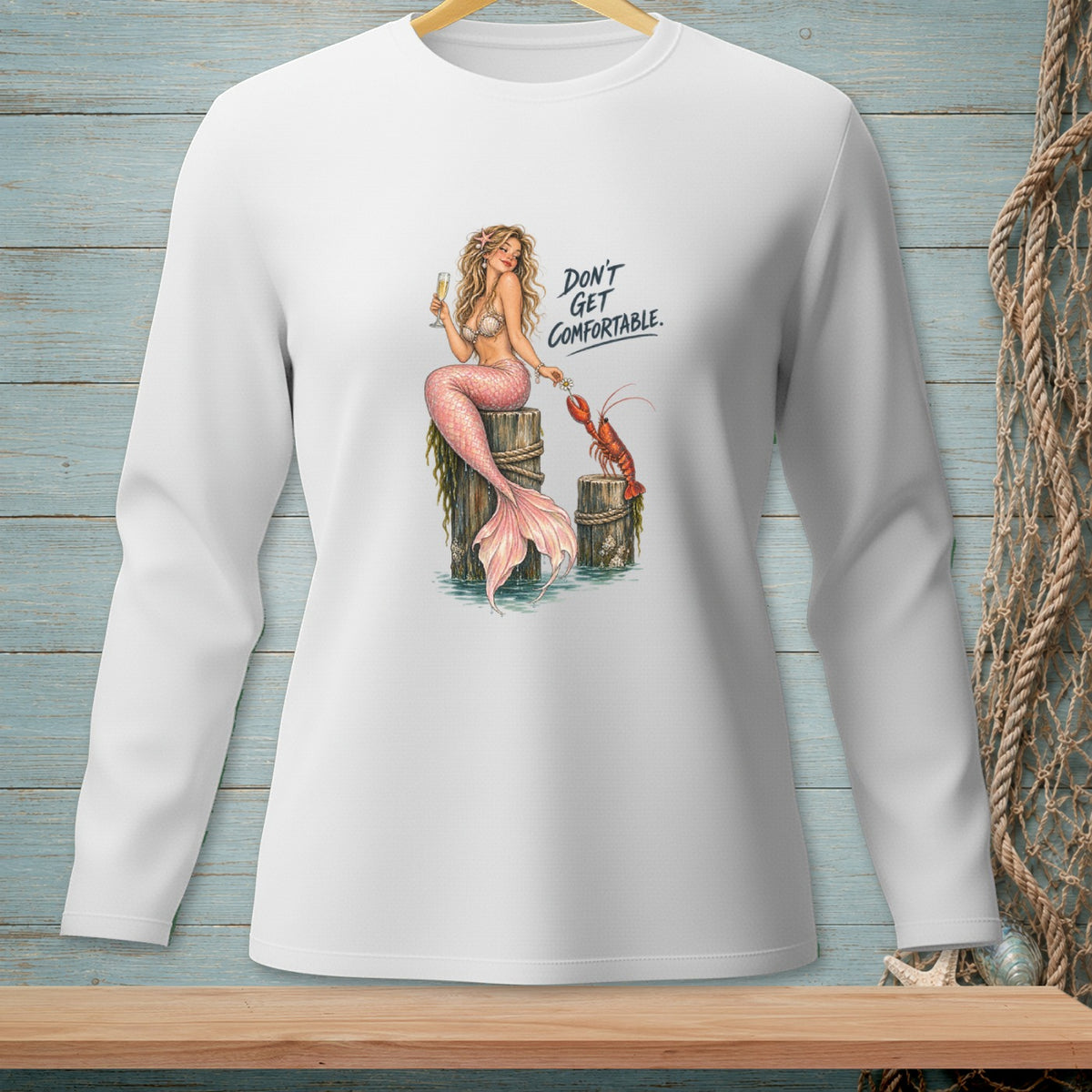 White long-sleeve shirt with mermaid and lobster graphic that reads "Don't Get Comfortable."