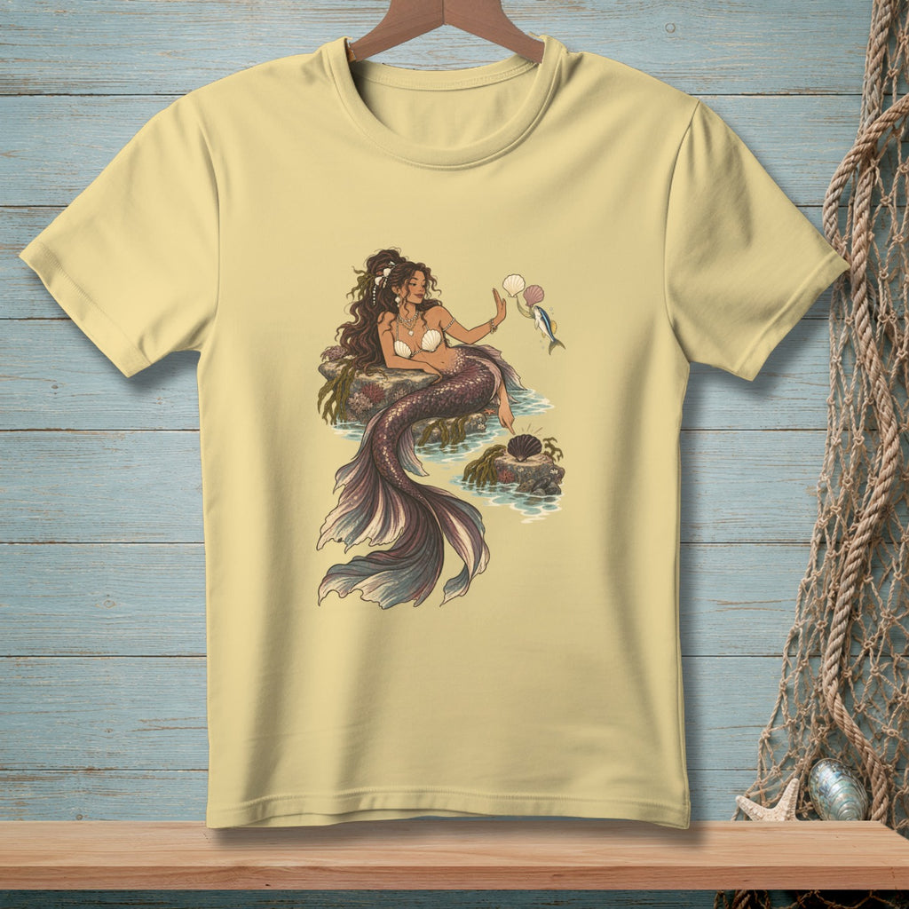 Illustration of a mermaid with fish and seashells on a pale yellow t-shirt.