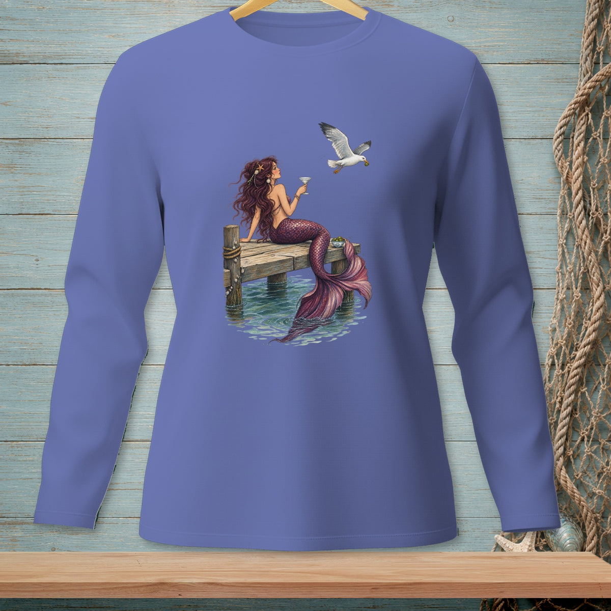 Mermaid sitting on dock with martini and a seagull holding food.